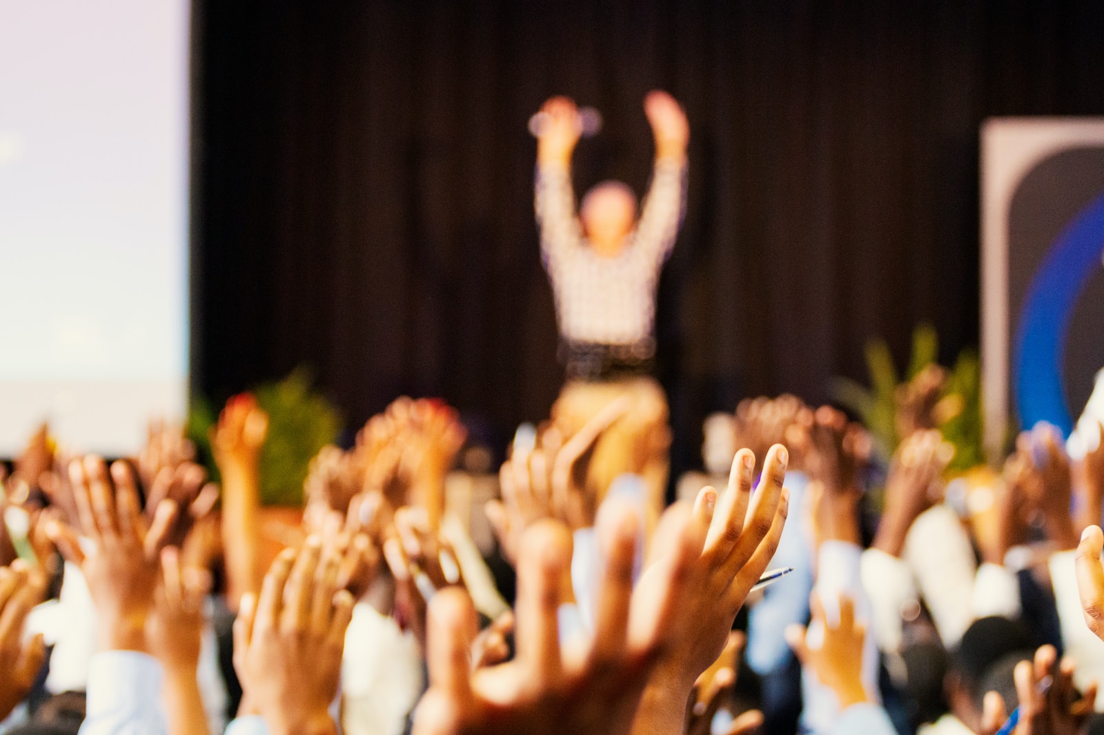 Actualités 3 people raising hands with bokeh lights
